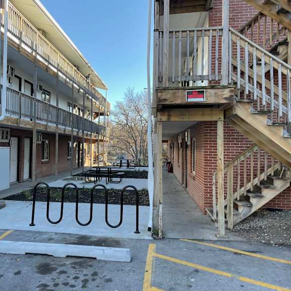 a parking lot with a car parked and a building with a staircase.