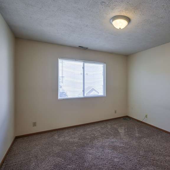 a room with a window and carpeted floor.