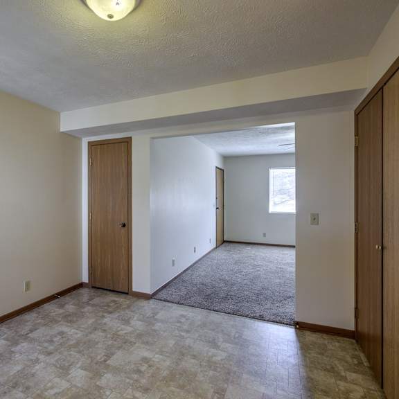 a room with a carpeted floor and two doors.
