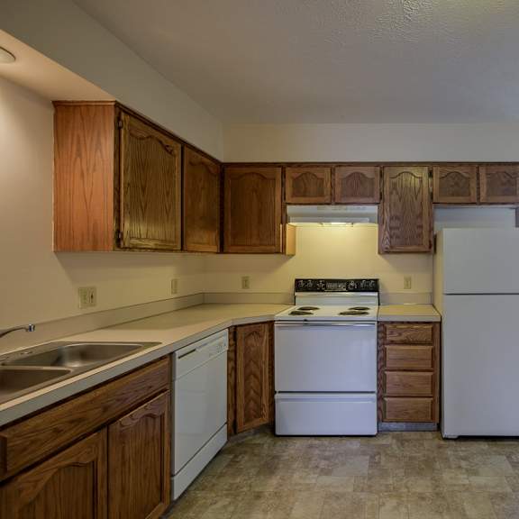 a kitchen with white appliances and wooden cabinets.