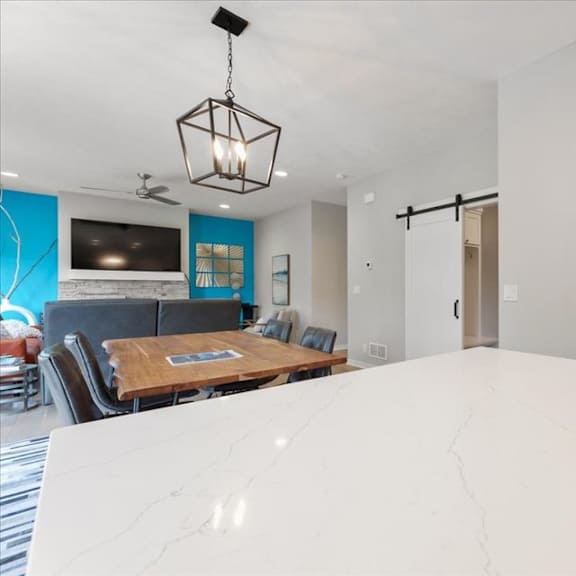 a modern kitchen with a wooden table and a refrigerator.