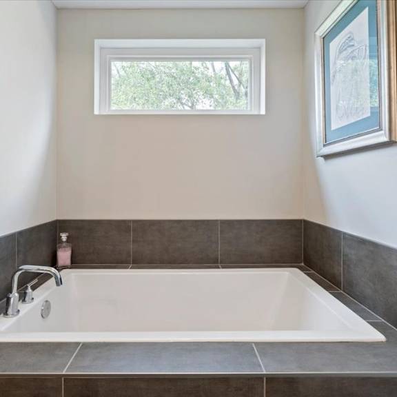 a bathroom with a tub and a window.