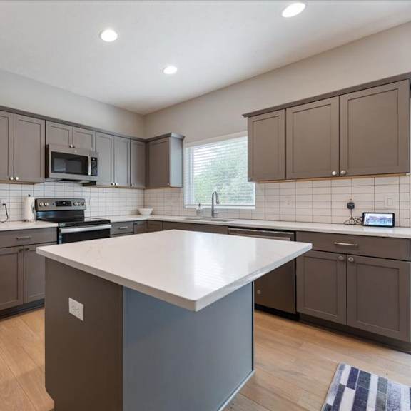 a kitchen with a white island in the middle.
