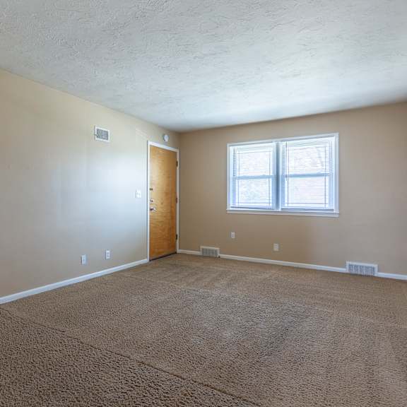 a room with a carpeted floor and a window.