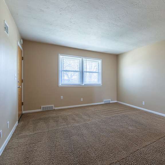 a room with a carpeted floor and a window.