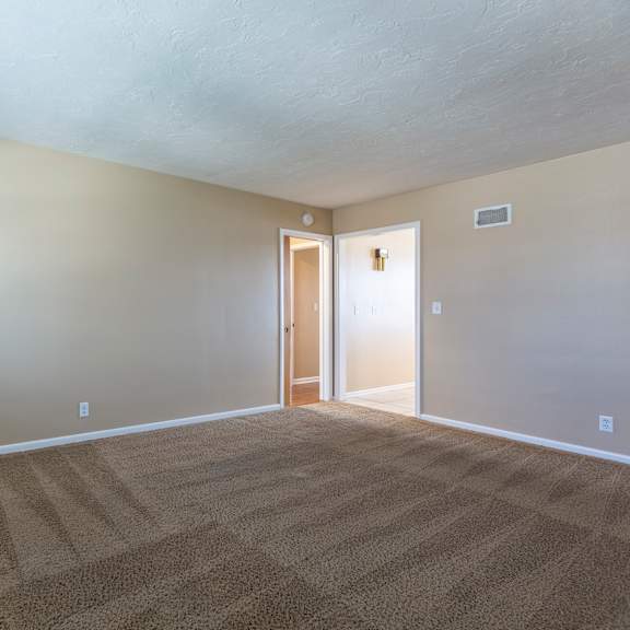 a room with a carpeted floor and a doorway leading to another room.