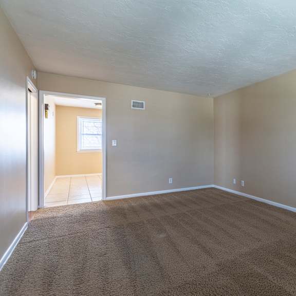 a room with a carpeted floor and a door on the right side.