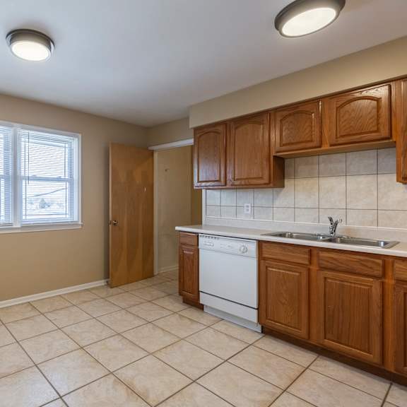 a kitchen with brown cabinets and a white dishwasher.