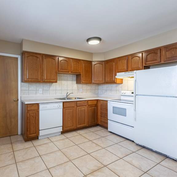 a kitchen with white appliances and wooden cabinets.
