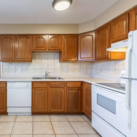 a kitchen with wooden cabinets and white appliances.