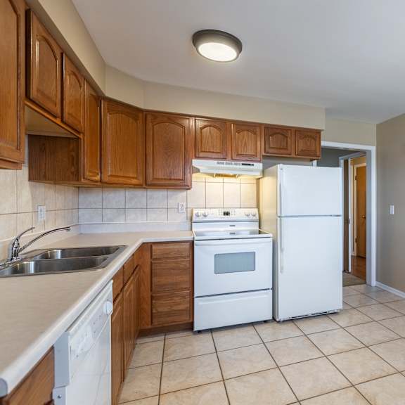 a kitchen with white appliances and wooden cabinets.