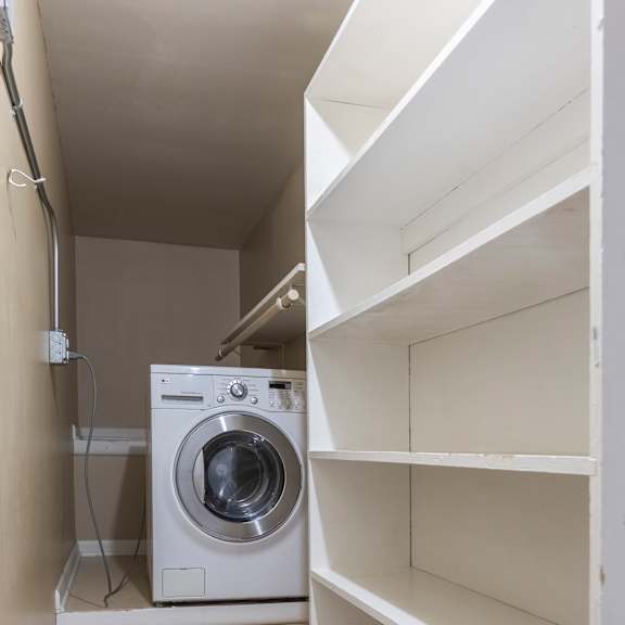 a white washing machine in a small laundry room.