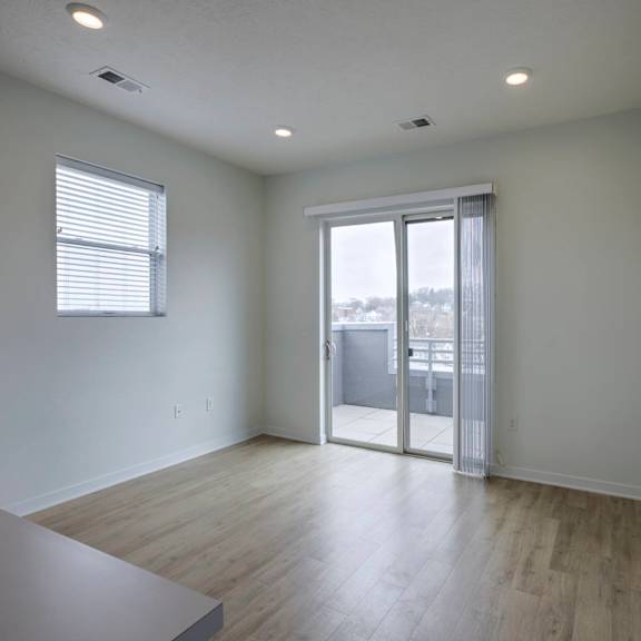a room with a sliding glass door leading to a balcony.
