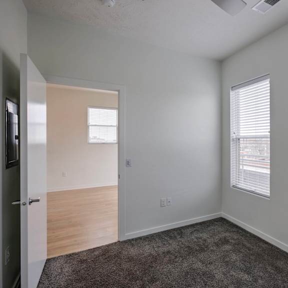 a room with a carpeted floor and a window with blinds.