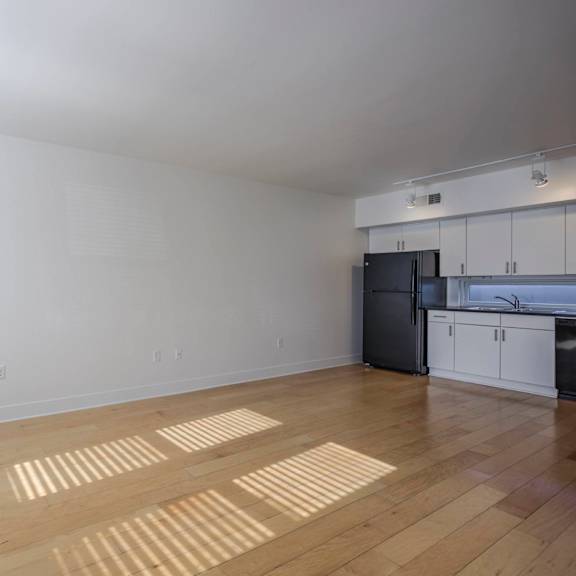 a room with wooden flooring and a window on the left side.
