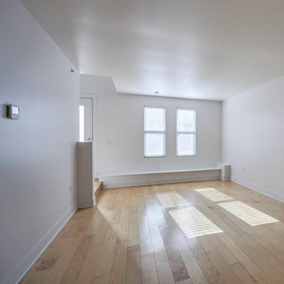 a room with wooden floors and white walls.