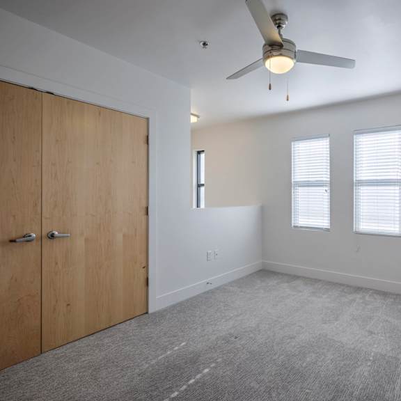 a room with a ceiling fan and a wooden door.