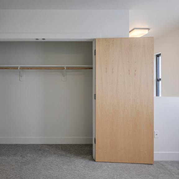 a room with a white wall and a grey carpet.