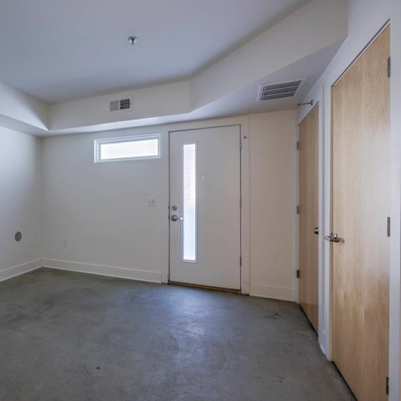 a room with a window, two doors, and a ceiling fan.