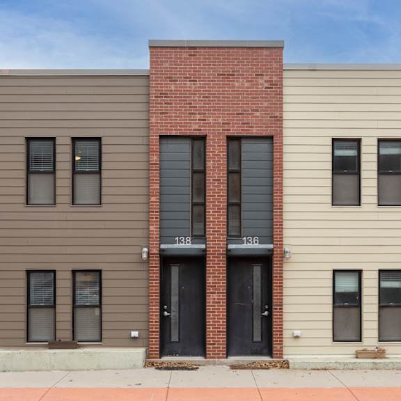a three-story building with a mix of brick and siding exterior.
