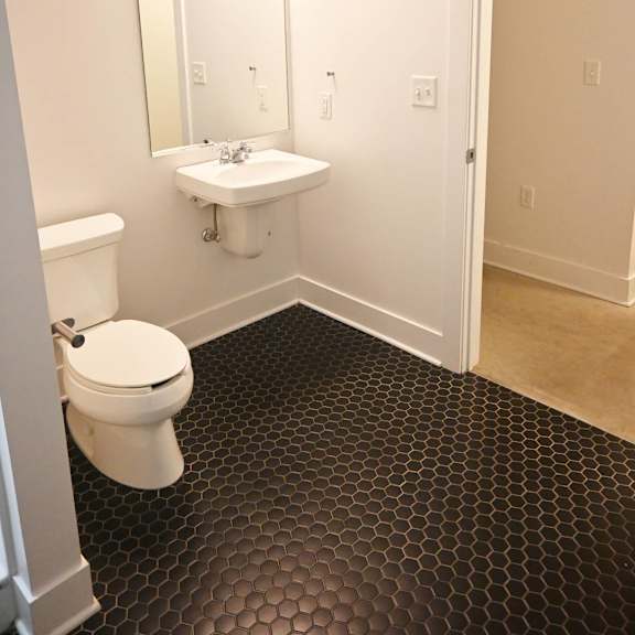 a bathroom with a toilet, sink and mirror.