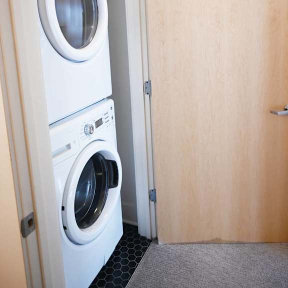 a white washing machine is in a small room.