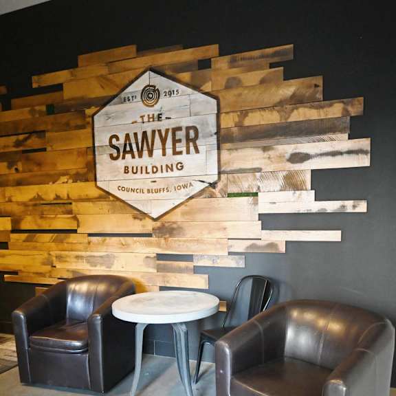 two black leather chairs are placed in front of a wooden sign that says