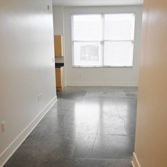a room with a large window and a wooden cabinet.
