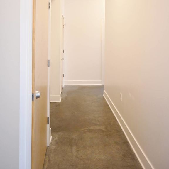 a long hallway with a door on the left.