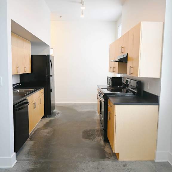 a kitchen with black appliances and wooden cabinets.