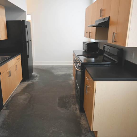 a kitchen with black appliances and wooden cabinets.