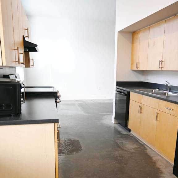 a kitchen with black countertops and wooden cabinets.