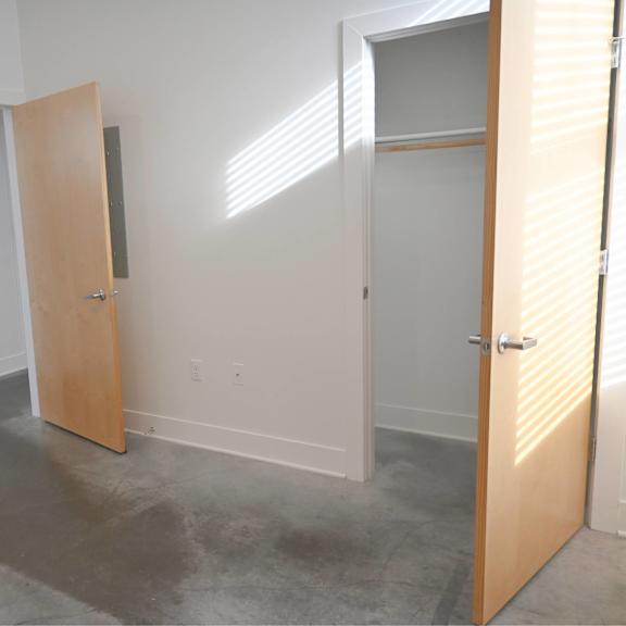 a room with a white wall and a wooden door.