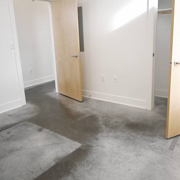 a room with two open doors and a concrete floor.