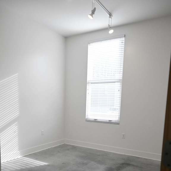 a room with a window and a concrete floor.