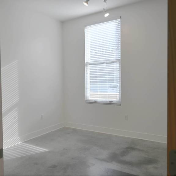 a room with a window and a grey floor.
