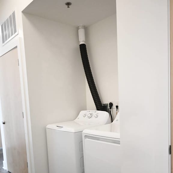a white washing machine is in a small room.