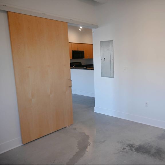 a room with a wooden door and a white wall.
