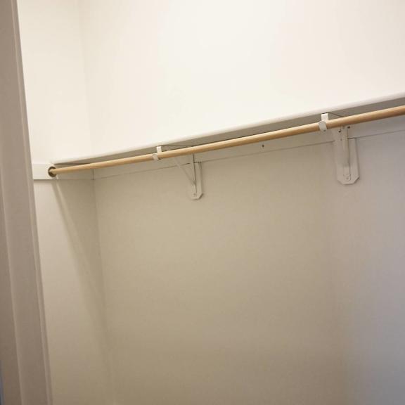 a white closet with a shelf and a white door.