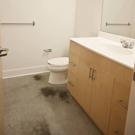 a bathroom with a toilet, sink, and mirror.