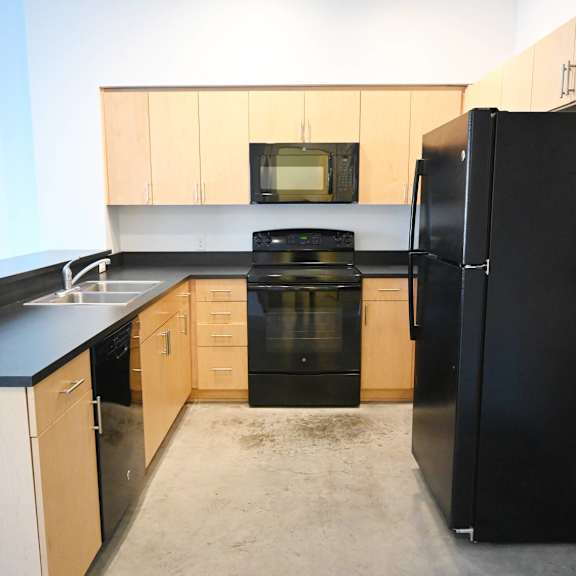 a kitchen with black appliances and wooden cabinets.