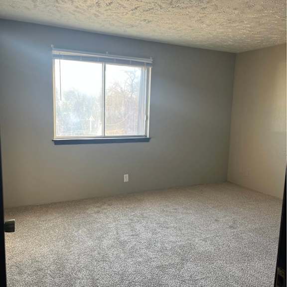 a room with a carpeted floor and a window.