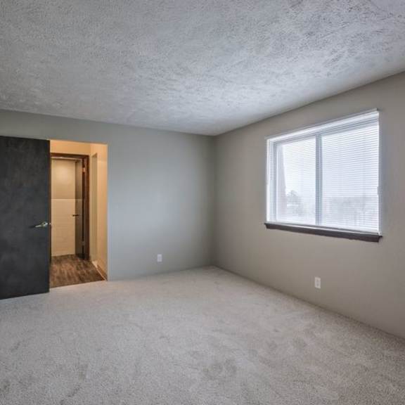 a room with a black door and a window with blinds.