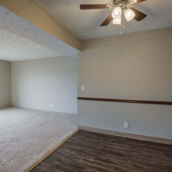 a room with a ceiling fan and a carpeted floor.
