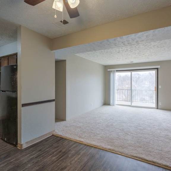 a room with a ceiling fan and a refrigerator.