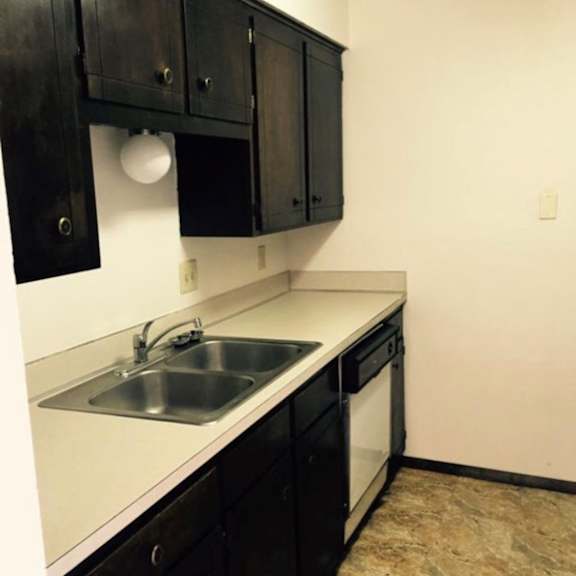 a kitchen with black cabinets and a white counter top.