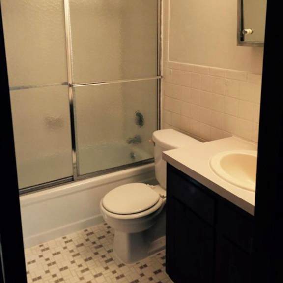 a white toilet sits in a bathroom next to a walk-in shower.