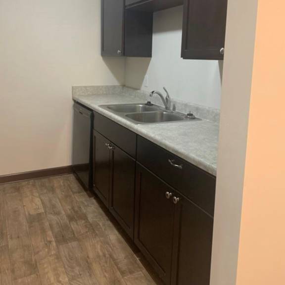 a kitchen with dark brown cabinets and a white countertop.
