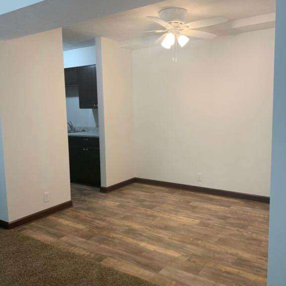 a room with a ceiling fan and a wooden floor.