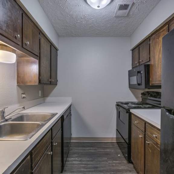 a kitchen with dark wood cabinets and stainless steel appliances.
